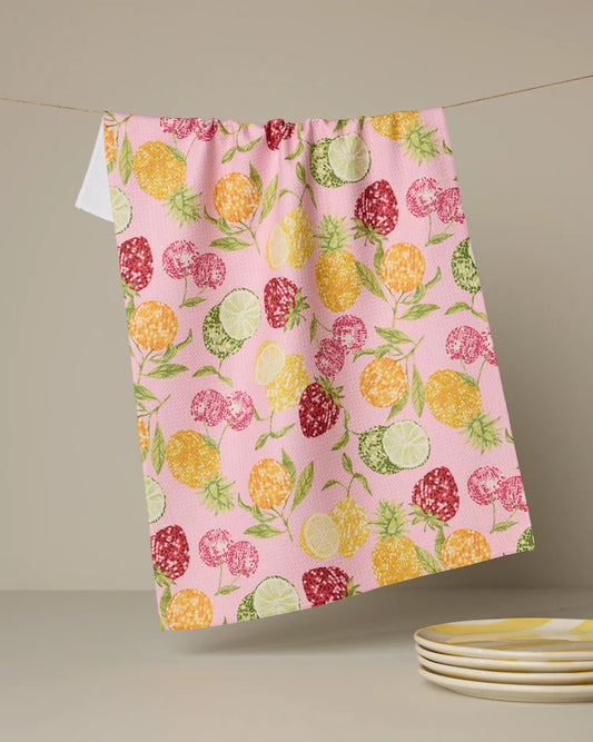 Geometry tea towel with Fruit disco patterned towel hanging on a line with plates below.