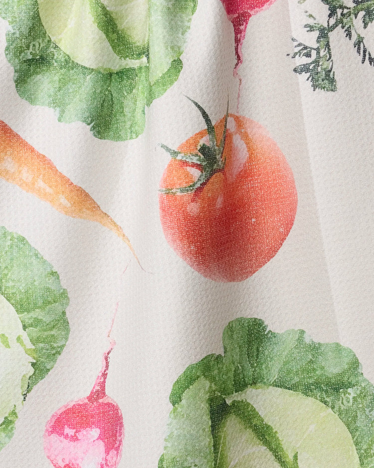 Spring Produce tea towel print by Geometry featuring a white towel with large print, colorful vegetables including tomato, carrots, cabbage, and radish.

