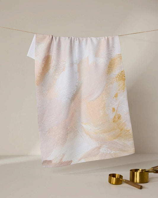 Geometry acete Towel with abstract design hanging on a line, with gold measuring cups below.