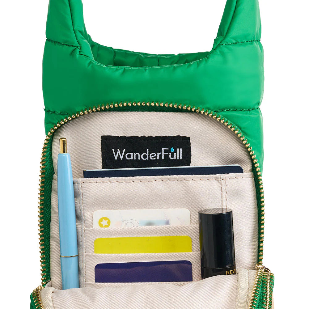 Green crossbody bag with 'WanderFull' branding, open to reveal items including a pen and small containers.