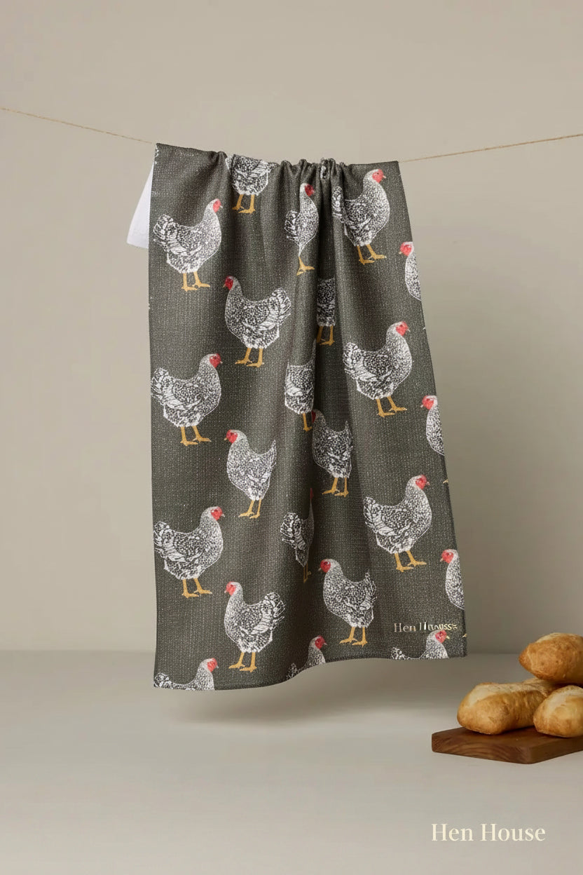 Geometry hen house tea Towel with chicken pattern hanging on a line against a beige background