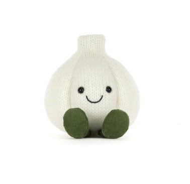 A knitted garlic-shaped plush toy with a smiling face, black embroidered eyes and mouth, and olive green feet, shown on a plain white background.