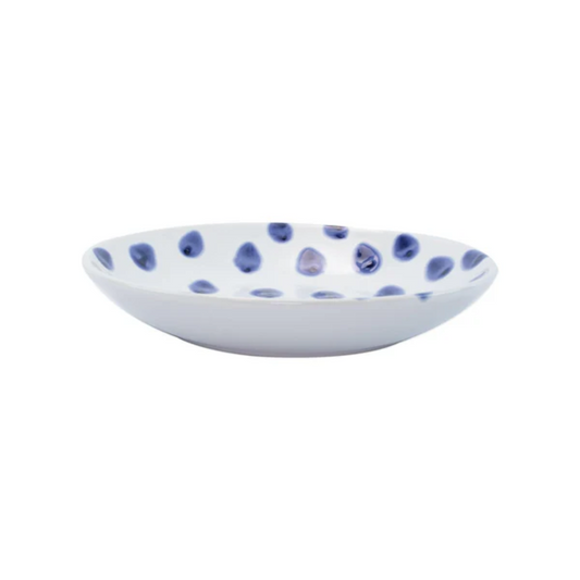 White ceramic bowl with blue polka dot pattern on a white background