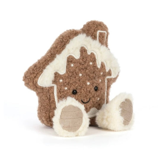 A plush gingerbread house toy with a brown textured body, cream-colored icing details, and a cute embroidered face, shown on a plain white background.