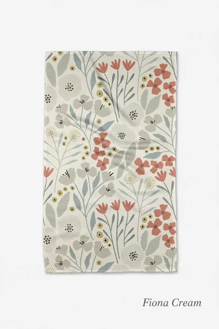 A kitchen Geometry fiona creme tea towel with a floral pattern in shades of pink, blue, and green on a beige background.