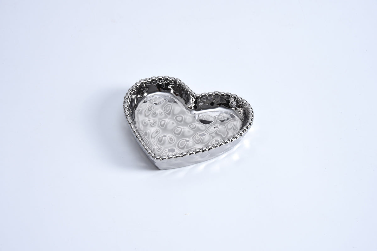 A small, heart-shaped, gold titanium finish ceramic dish with lustrous beads around the edge, displayed on a white background.