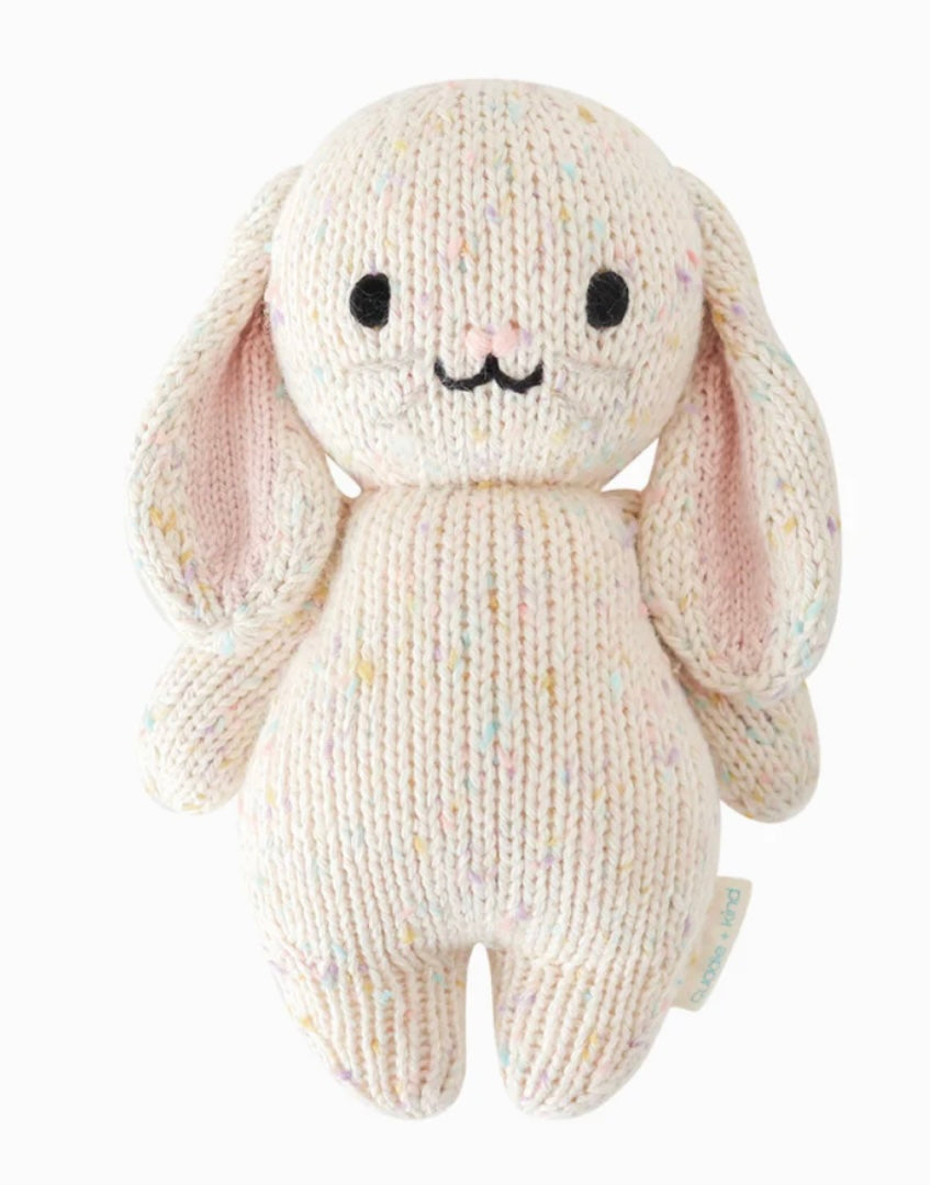 Hand-knit beige plush toy in the shape of a baby bunny with pink inner ears and a happy facial expression.