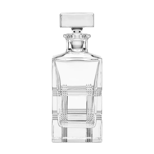 A clear crystal decanter by Reed and Barton with a square shape and a tailored design, featuring a stopper on the top.
