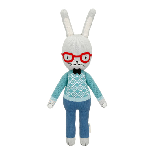 Knitted bunny toy with red glasses, blue sweater, and pants on a white background