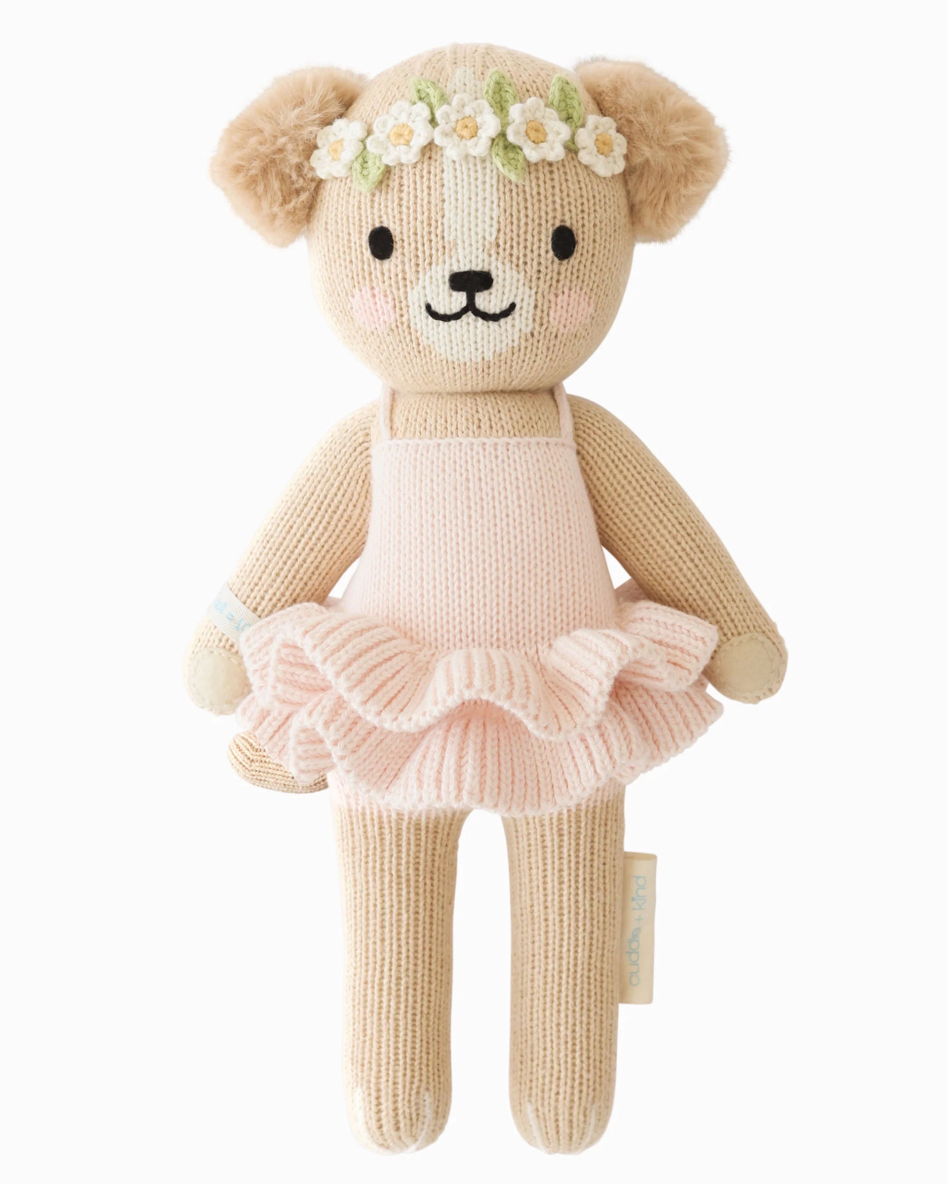 Knitted puppy in a pink tutu dress with a flower crown on a white background