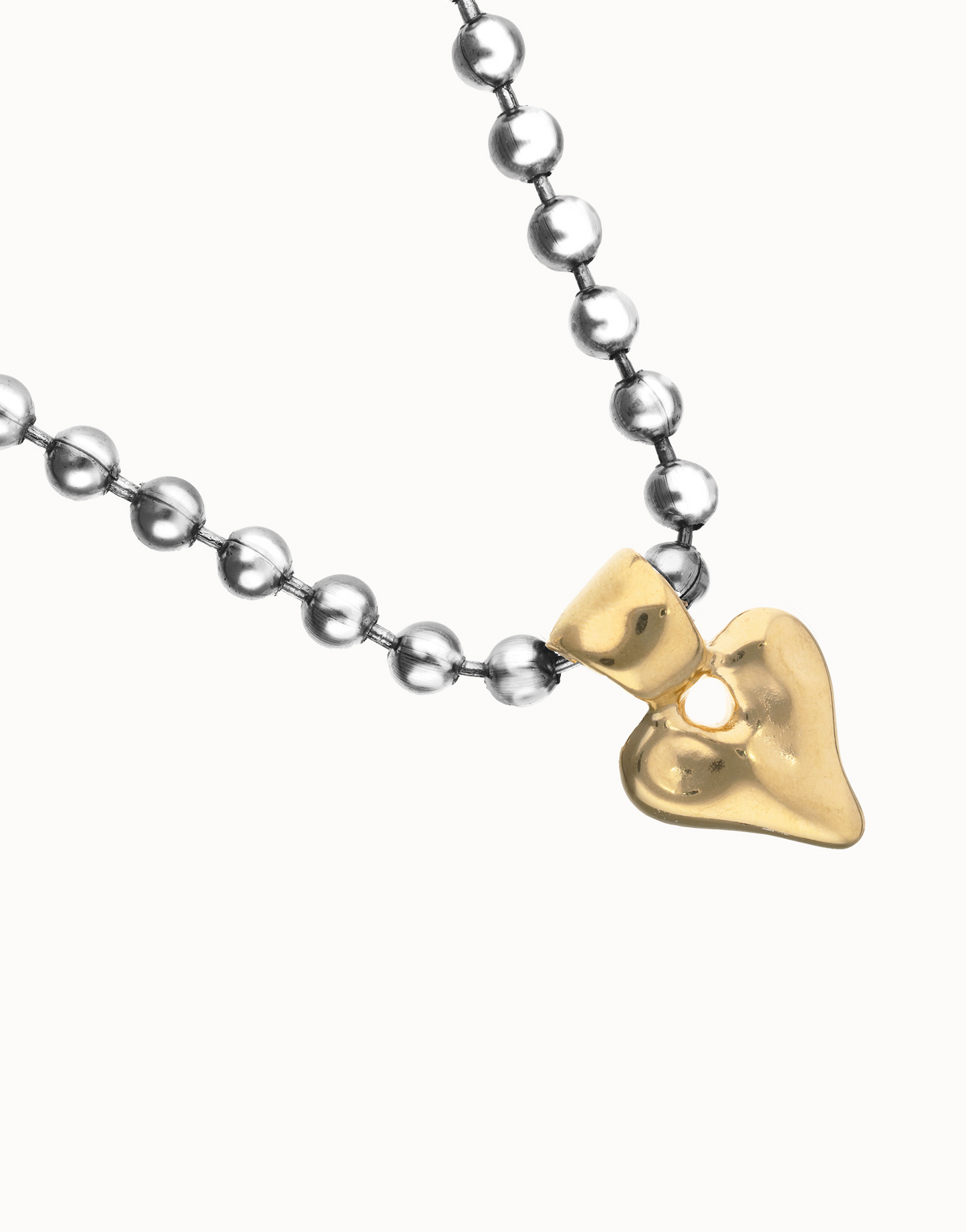 Uno de 50 Necklace with a gold heart-shaped pendant on a white background