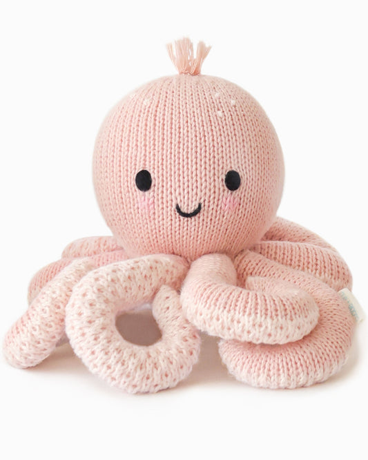 Knitted pink octopus toy with a smiling face on a white background