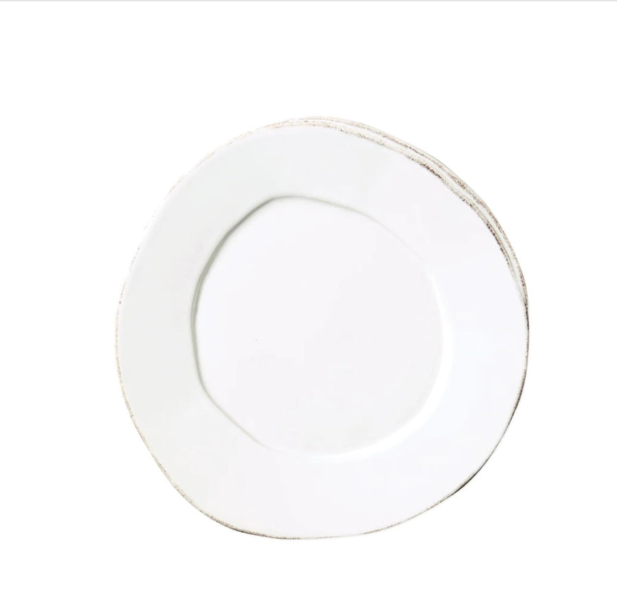 A white salad plate with rustic brown highlights.