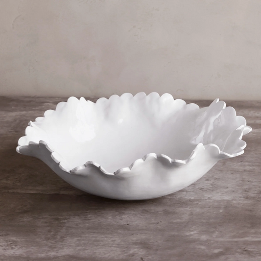 White ceramic bowl with scalloped edge on a gray surface