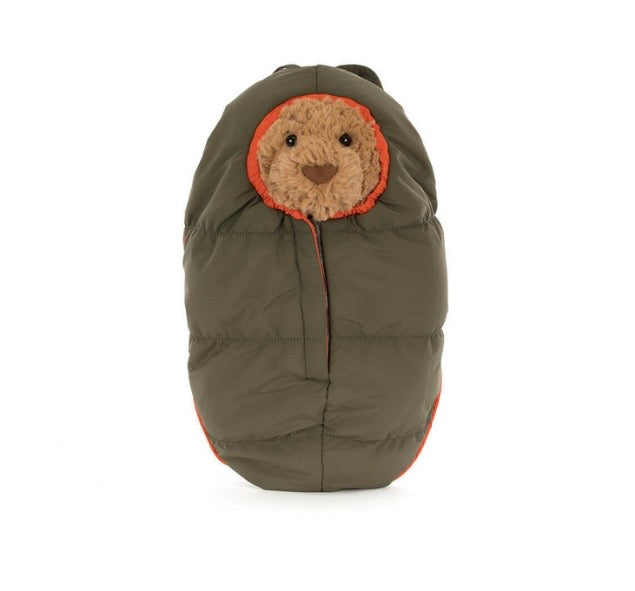 Bear plush toy with a face peeking out of green sleeping bag 
