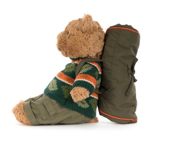 Teddy bear wearing a green coat with a hood on a white background