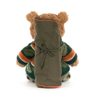 Stuffed bear wearing a green coat with a hood on a white background