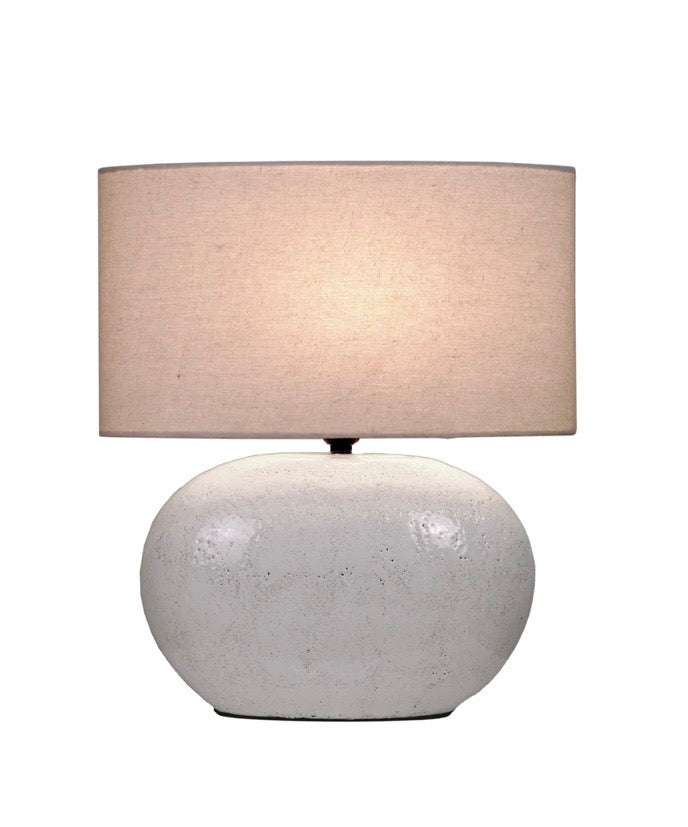 Table lamp with a textured white base and beige fabric shade 