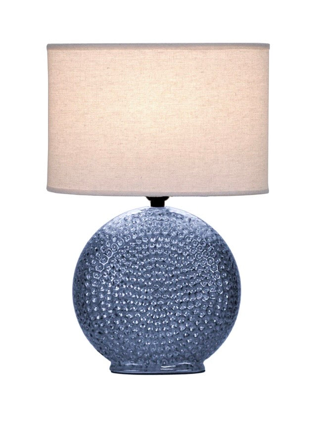 Table lamp with textured blue base with a spiral design and beige lampshade 