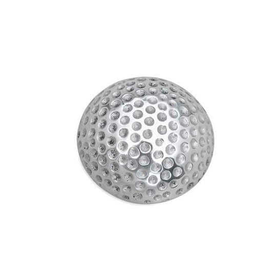 A silver golf ball-shaped napkin weight made of recycled aluminum.