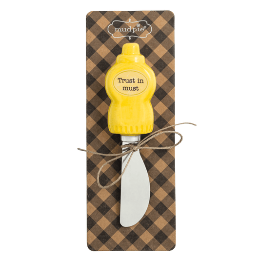 Mustard bottle shaped spreader on a checkered card with 'mudpie' brand