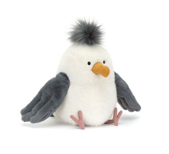 A plush bird toy with a fluffy white body, dark gray wings, a yellow beak, and a black-and-white pom-pom crest on its head, photographed on a clean white background.