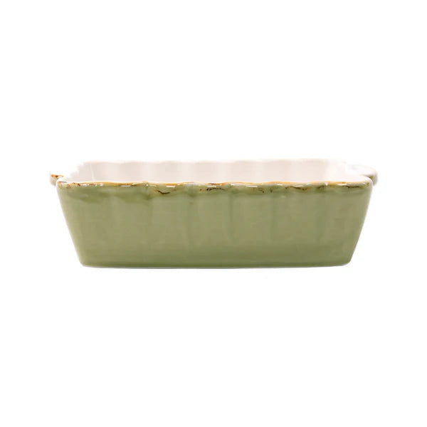 Green ceramic rectangular baking dish with a white interior and scalloped edge
