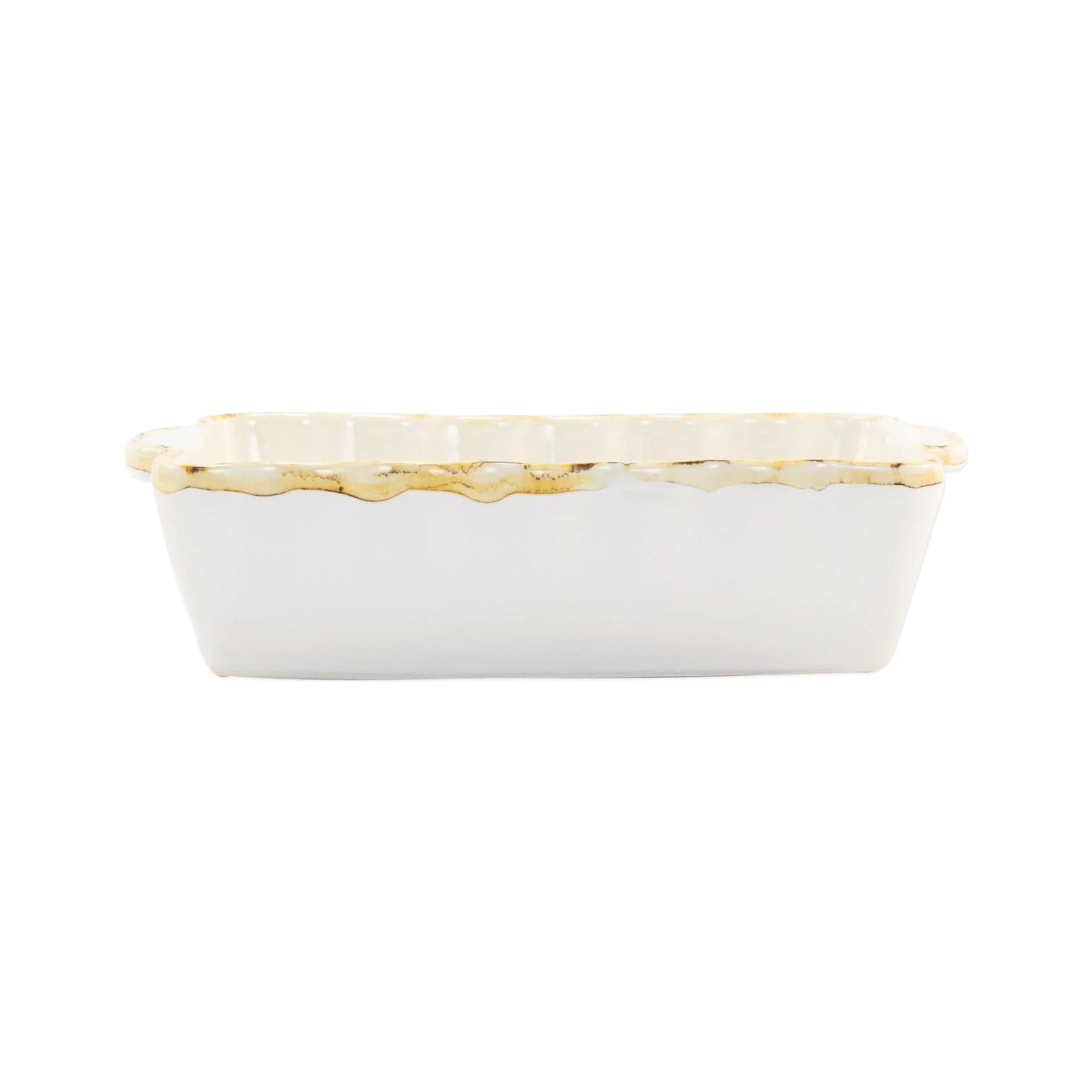 A small rectangular white stoneware baker with scalloped edges and a rustic rim.