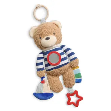 Teddy bear Itzy Ritzy Bitzy Traveler Developmental Sensory Toy- Bear toy with striped shirt and colorful accents on a white background