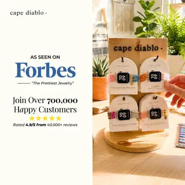 Jewelry display with 'cape diablo' branding and 'Forbes' endorsement on a white background.