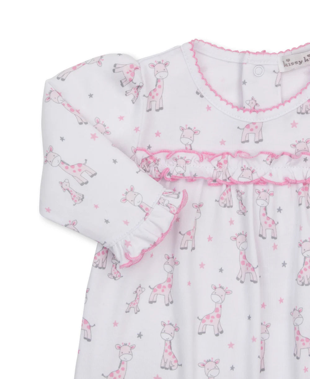 Close up of the details of a Kissy Kissy Just Giraffes pink playsuit featuring pink ruffles across the chest and at the arm opening and baby giraffes in gray and pink