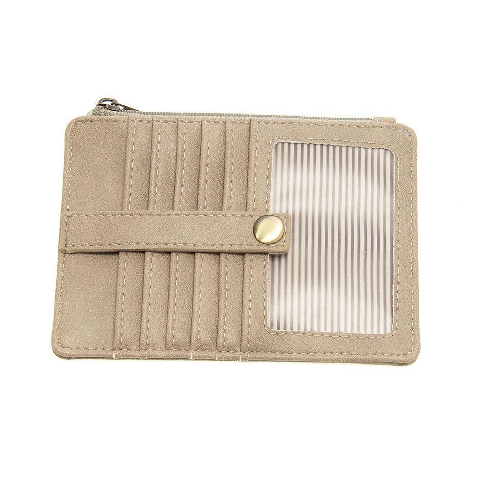 A heathered gray vegan leather mini travel wallet with a top zip closure, multiple card pockets, an ID window pocket, and an exterior passport pocket. It has brass plated hardware and is slim enough for travel use.