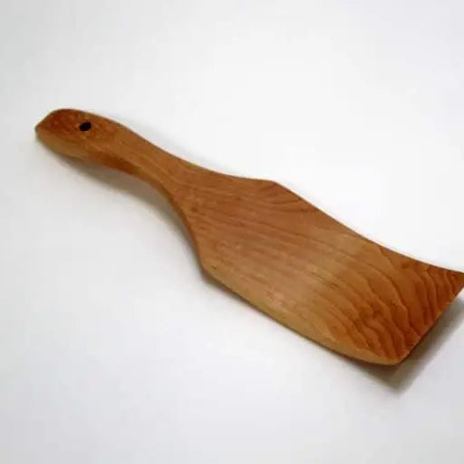 A natural wood paddle or spatula with a smooth grain and a small hole in the handle, shown on a plain white background.