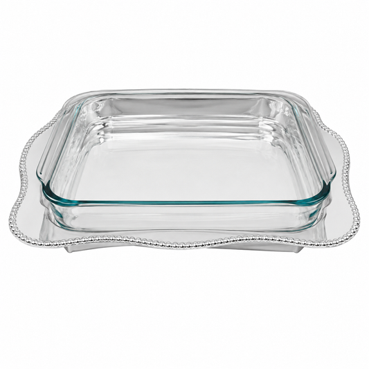 A clear glass baking dish with a silver Mariposa 3613 Sueno oblong casserole caddy with  scalloped beaded tray underneath, shown on a plain white background.