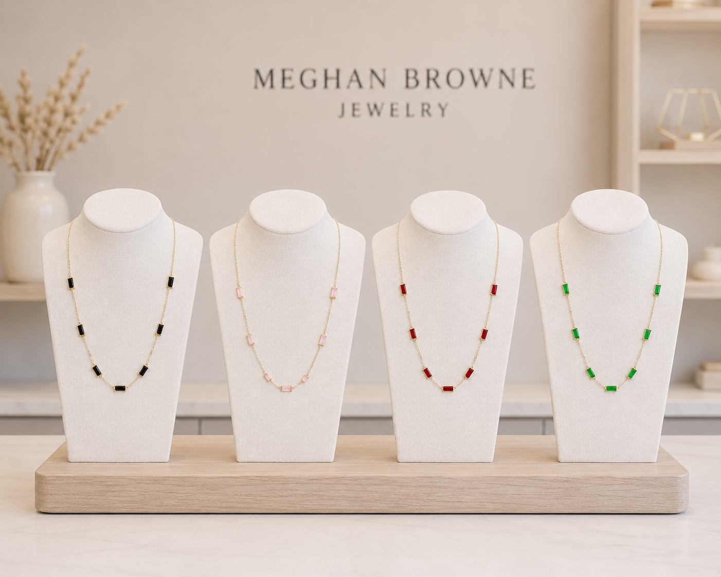 Meghan Browne FIZ necklaces in a jewelry display all gold chain necklaces with rectangular stationary stones in black pink red and green
