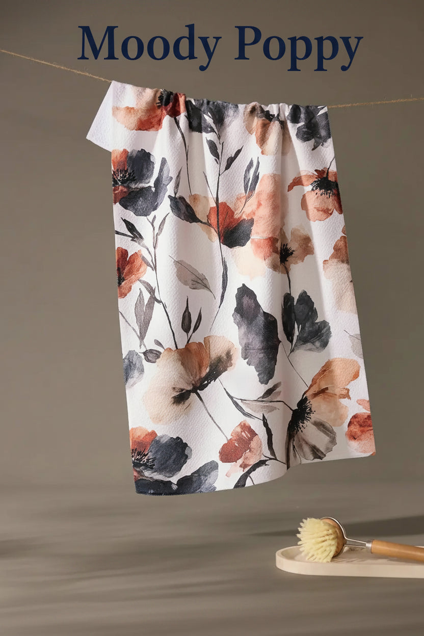 Floral patterned Geometry moody poppy tea towel hanging on a line with a neutral background
