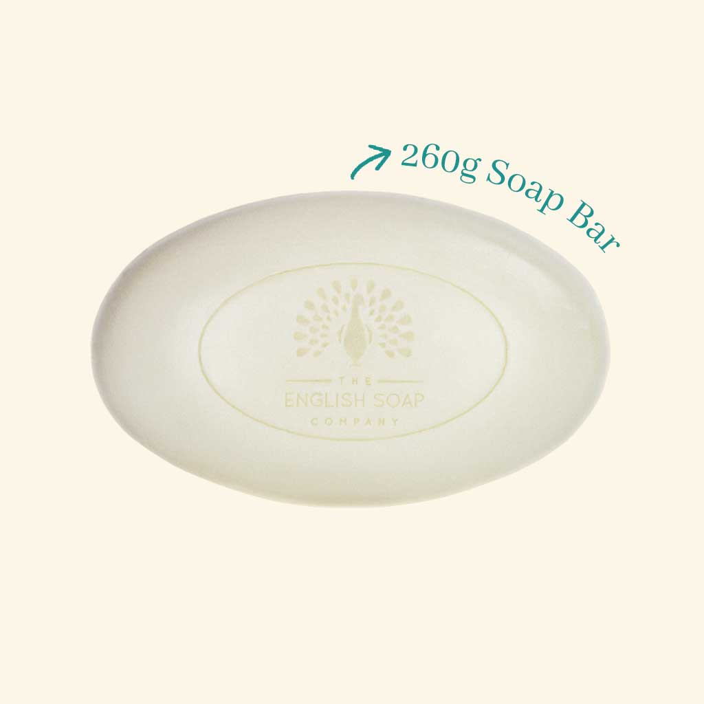 Naked bar of 260g bar soap by the english soap company and christina may with the company logo in the  middle of an oval bar