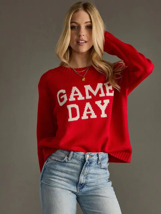 Woman wearing a red 'GAME DAY' Panache sweater against a gray background