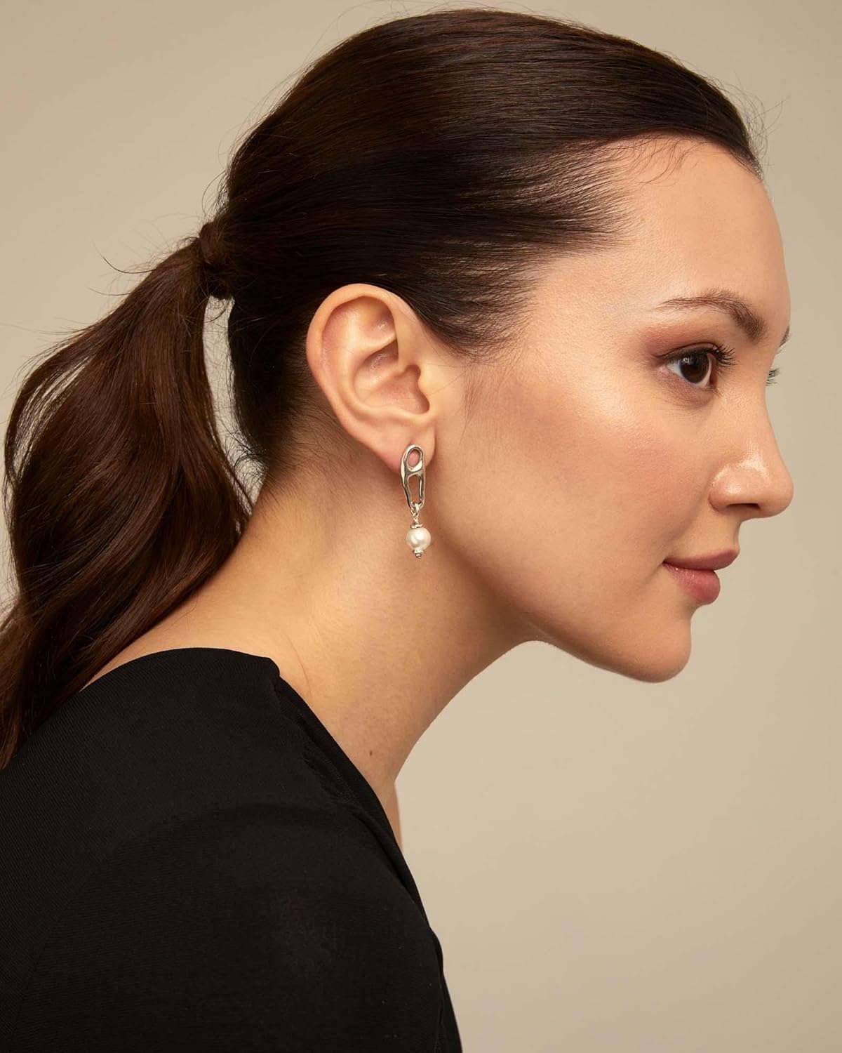 Woman in black shirt wearing UNOde50 Pearl & Match Elongated Silver Double Link Earrings with Pearl Accent