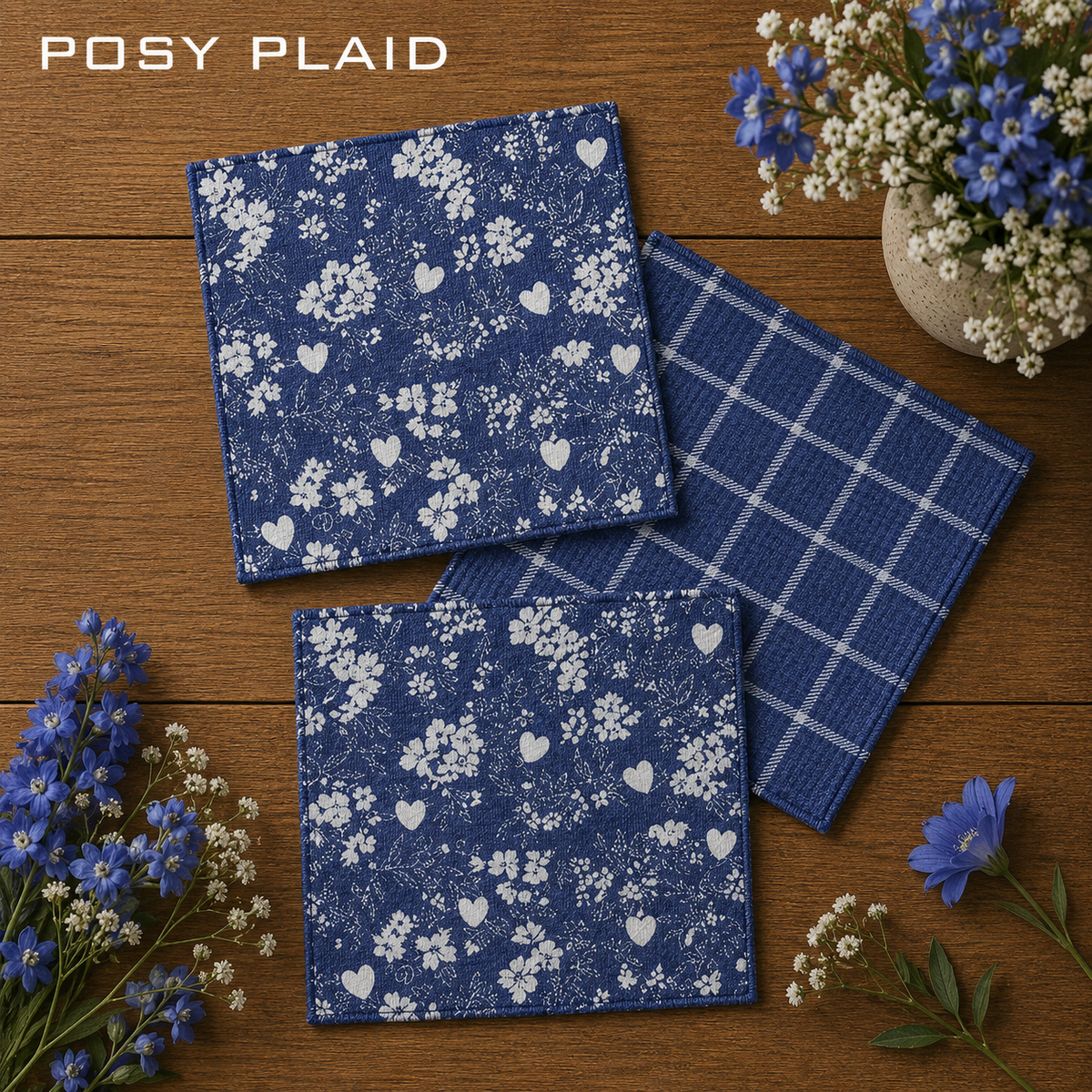 Geometry Posy Plaid dishcloth set of three square woven navy blue dishcloths.  Two cloths have a white floral and heart pattern and the other has plaid white stripes.  The Little Exchange SKU 150056