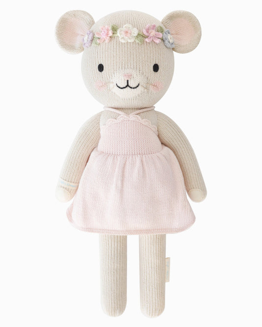 Hand knit toy mouse with a pink dress and floral headband on a white background