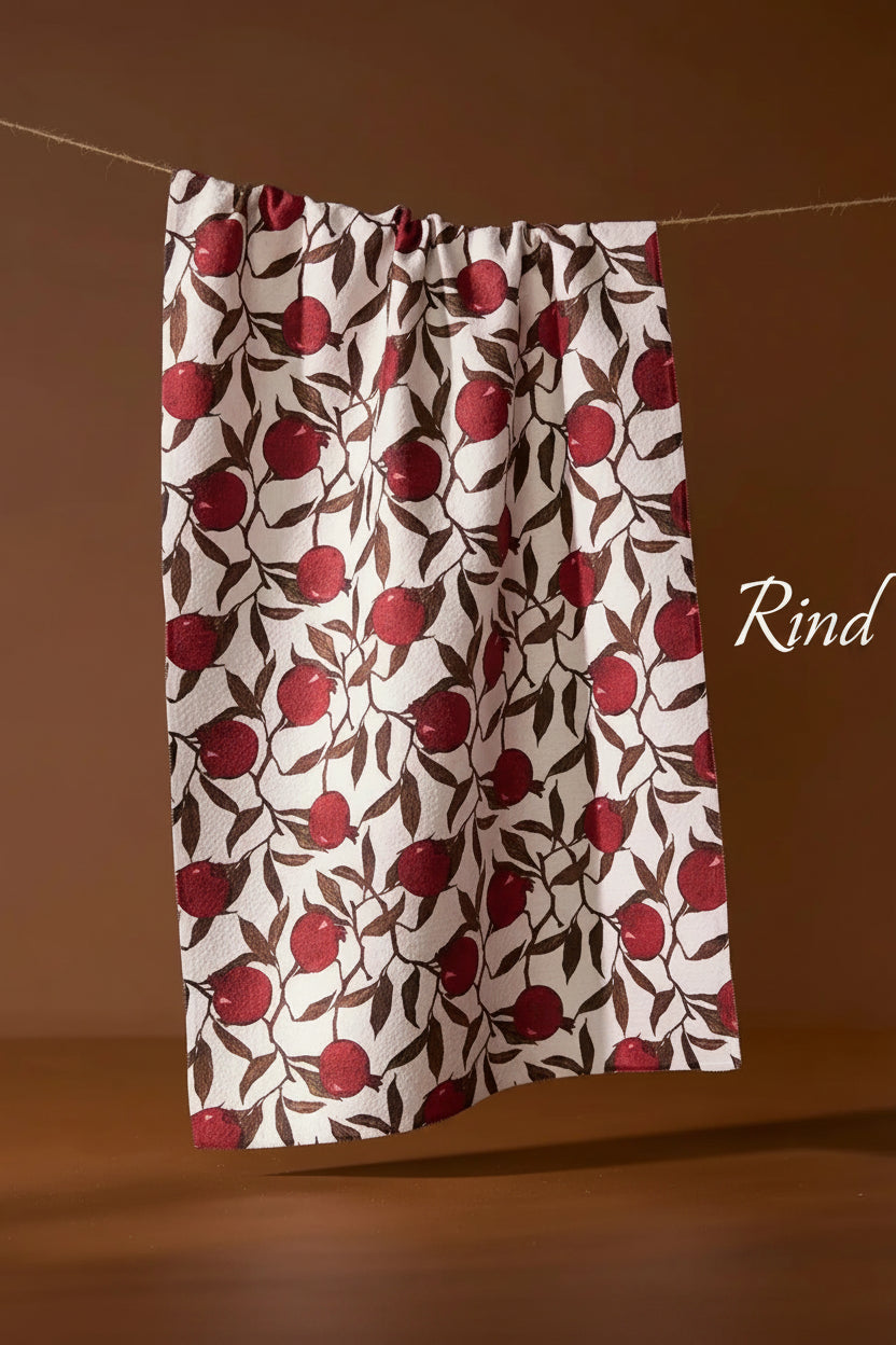 Geometry rind tea towel with red apple pattern hanging on a line against a brown background