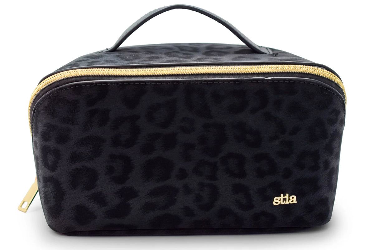 Black leopard print cosmetic bag with gold zipper and a small gold 'stla' logo on the front, shown on a white background.
