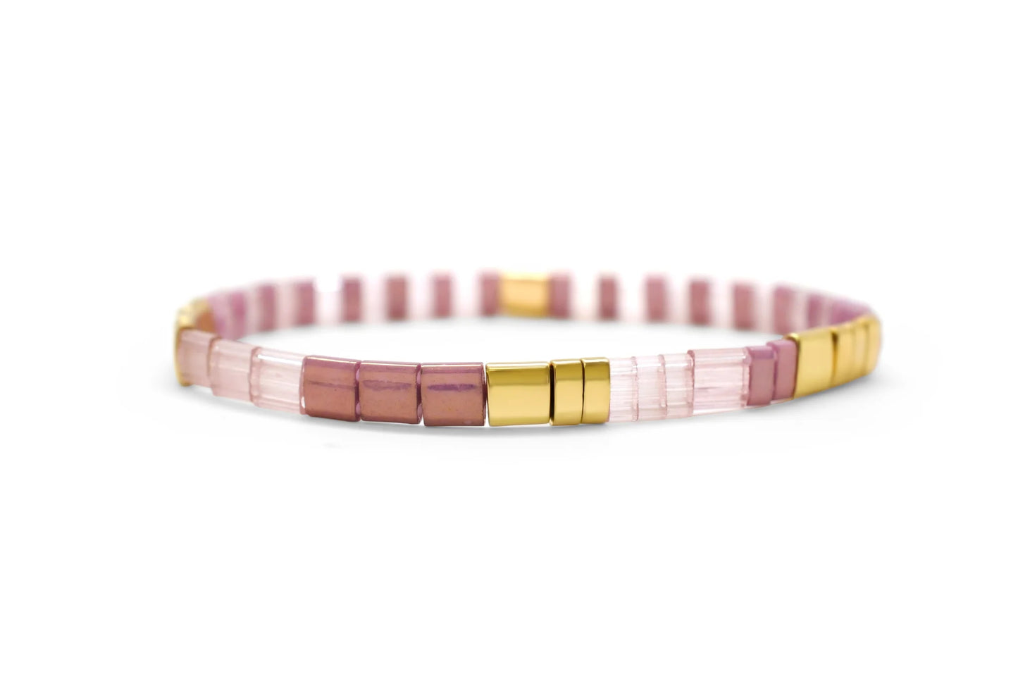 Morse code bracelet with pink and gold tila beads on a white background