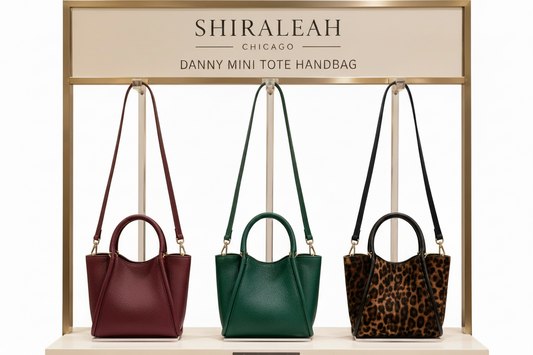 Three Danny mini tote handbags displayed on a stand with 'Shiraleah' branding.