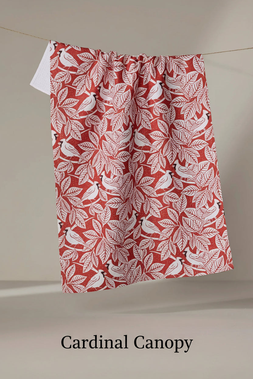 Red Geometry cardninal canopy tea towel with white leaf and bird pattern hanging on a line against a neutral background