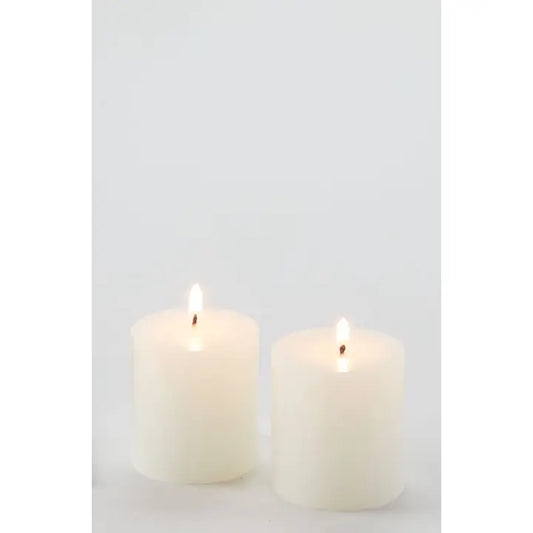 Two white candles on a light gray background