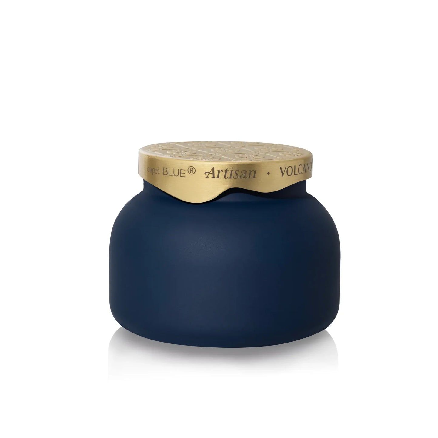 A dark navy blue jar with a textured gold lid, featuring the brand name 'Capri  Blue' and product line 'Artisan Volcano' printed on the gold band.