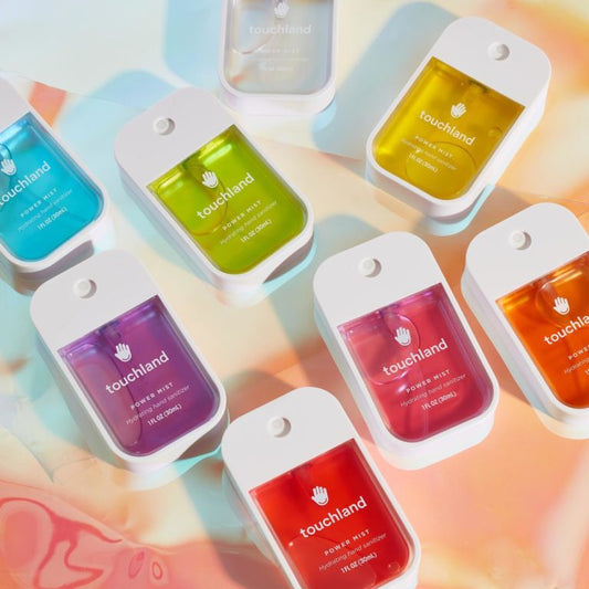 Touchland power mist packaging in various colors on a colorful background