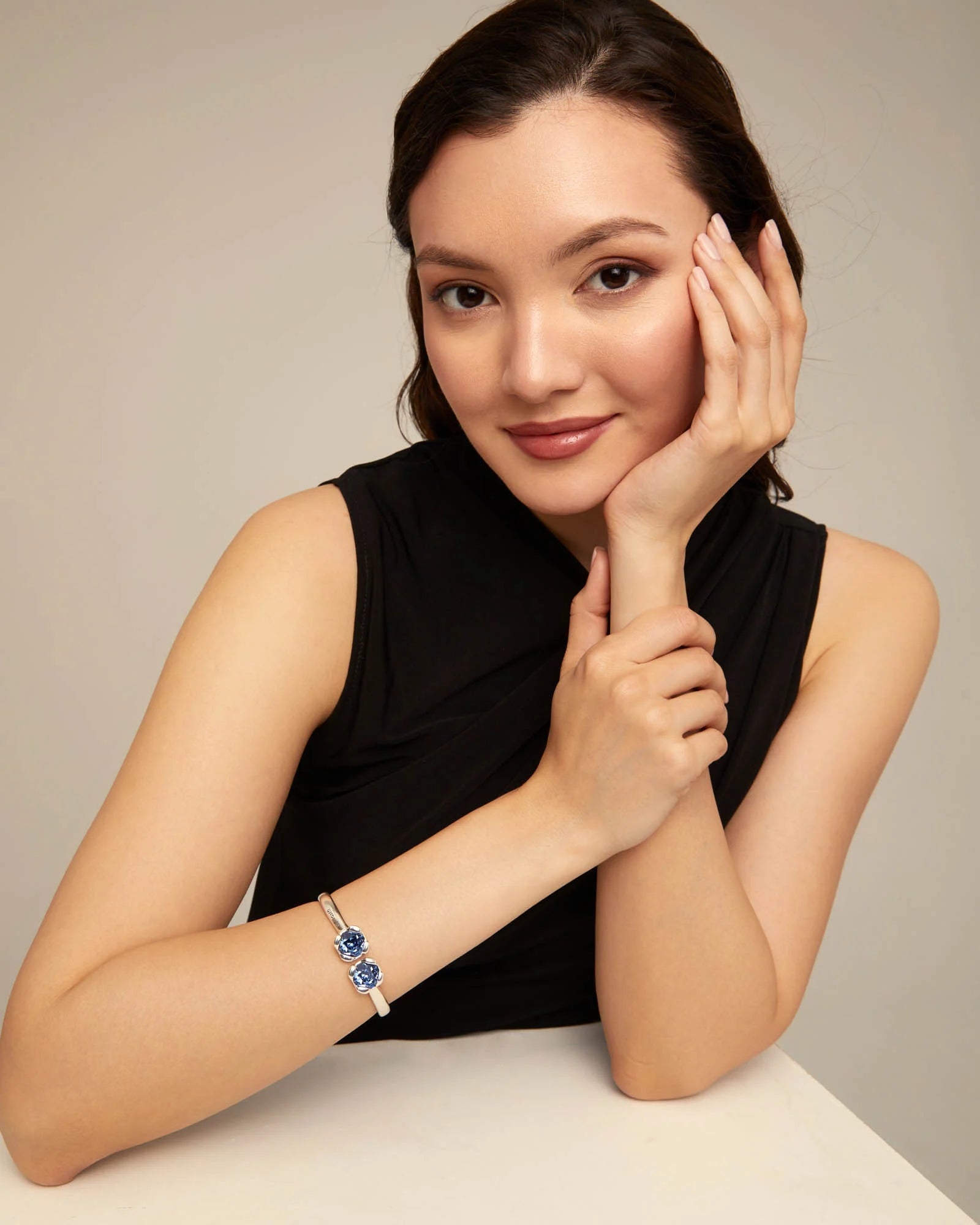 Woman with black top wearing an UNOde50 Aura Blue Silver Bangle Bracelet with two Blue Crystals